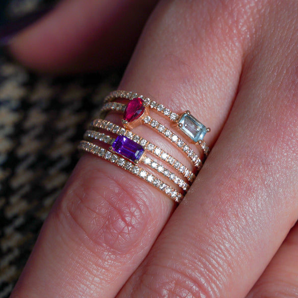 Purple sideway emerald cut sapphire with a pavé band